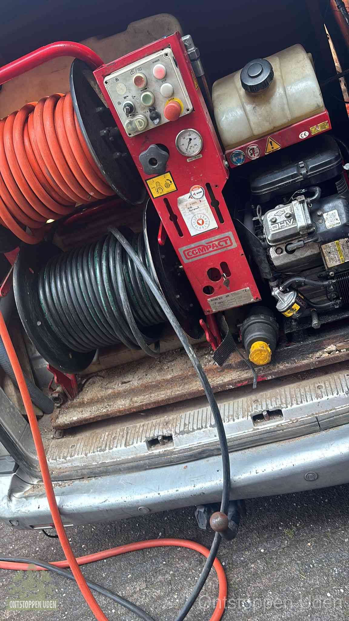 Een rood hogedruk-rioolreinigingstoestel met slangen in de laadbak van de bedrijfsbus, apparatuur voor een hardnekkige wc-verstopping in Uden