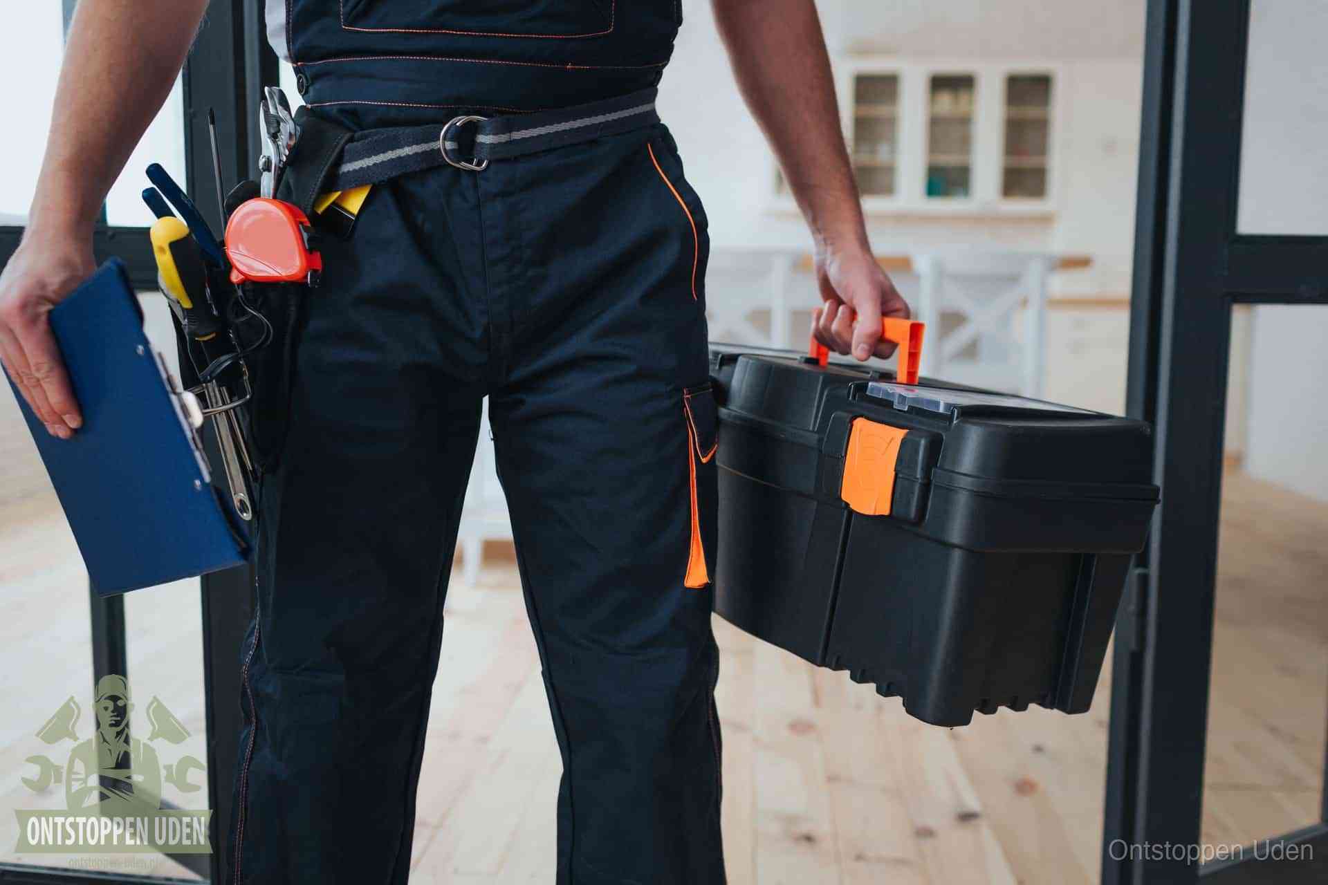 Een monteur met gereedschapsriem en klembord, klaar om een transparante prijs voor het wc ontstoppen in Uden te geven