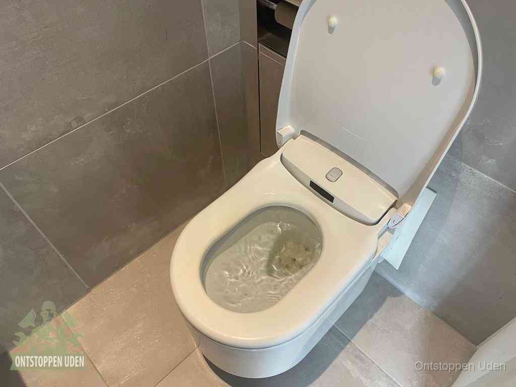Een toiletpot vol troebel water met drijvend papier en restanten, de meest voorkomende oorzaak van een verstopte wc in Uden