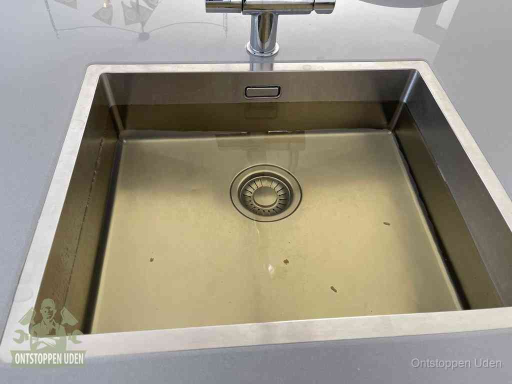 Stilstaand water in een rvs spoelbak dat niet wegloopt, een duidelijk signaal van een gootsteenverstopping in Uden
