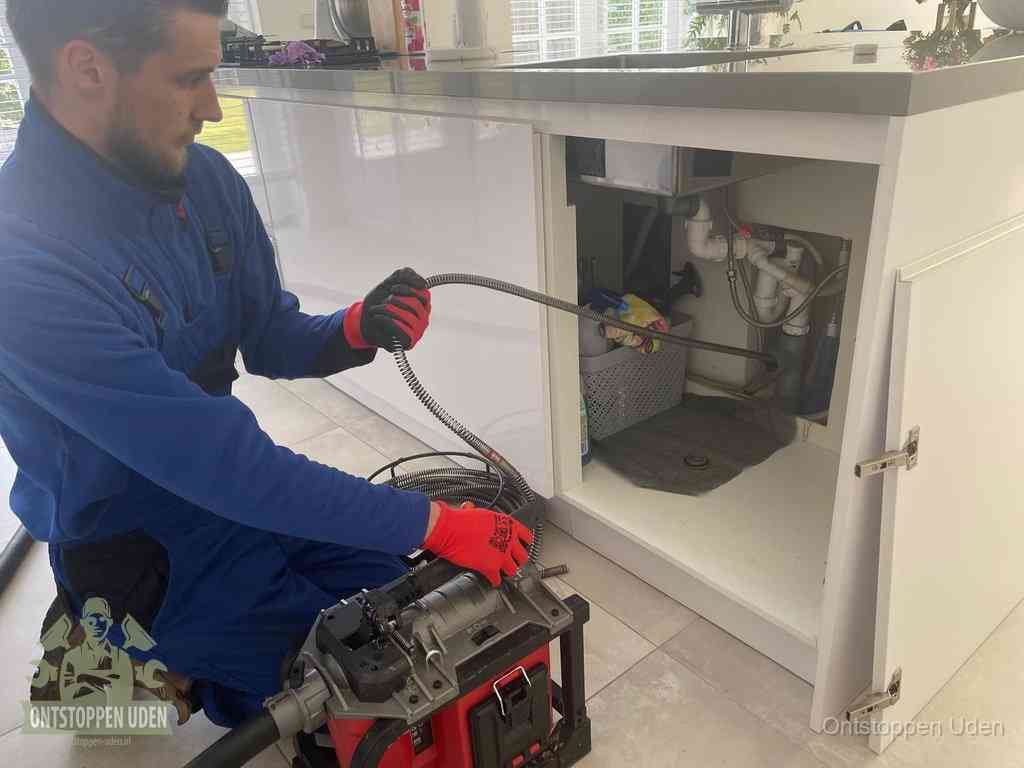 Een monteur reinigt de keukenafvoer grondig met een veermachine om terugkerende gootsteenverstoppingen te voorkomen in Uden